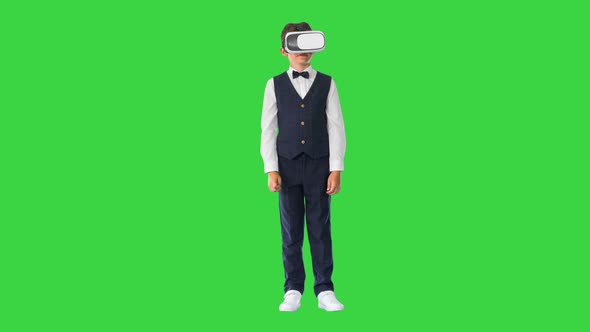 Excited Boy in Formal Wear Playing in Virtual Reality Goggles on a Green Screen Chroma Key