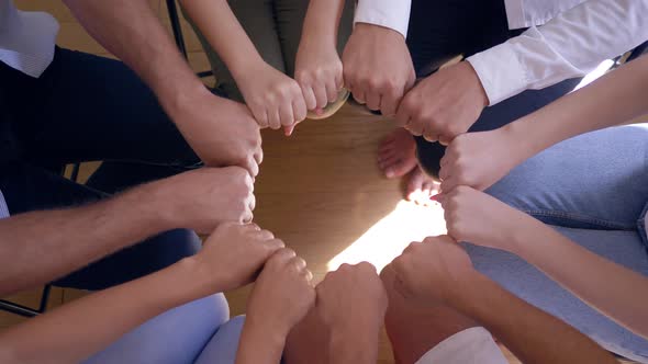 People with Clenched Fists Make Circle and Then Applaud Each Other Sitting on Chairs on Group