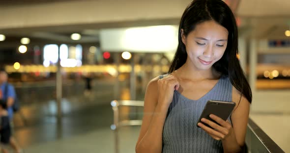 Woman working on smart  phone in the city at night 