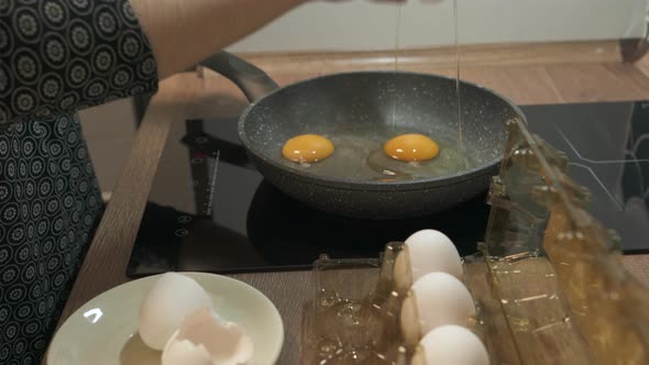 Fresh Eggs Break in Hot Frying Pan on Stove