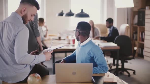 Two Young Multiethnic Colleagues Work Together in Modern Loft Coworking Space, Busy Office Teamwork