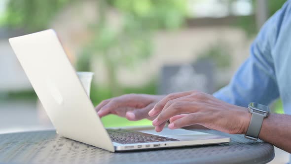 Close Up of African Man Typing on Laptop