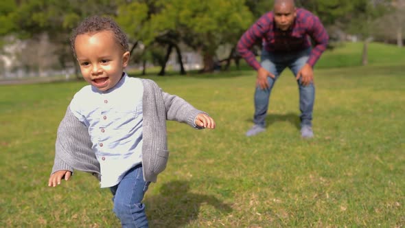 Little Mixed-race Boy in Park Running From Father To Mother