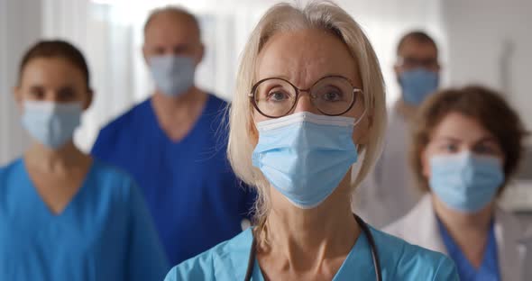 Portrait of Medical Staff in Uniform an Protective Mask Looking at Camera