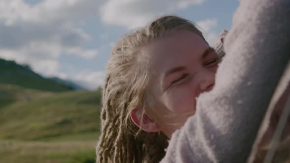 Young woman with dreadlocks and closed eyes traveling by car while road trip.