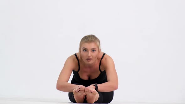 Sexy girl doing fitness exercises. Shooting in the studio on a white background