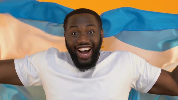 Happy Sport Fan Holding Flag of Argentina on Yellow Background, Game Audience