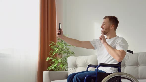 Happy Disabled Person Sitting in a Wheelchair and Taking a Selfie