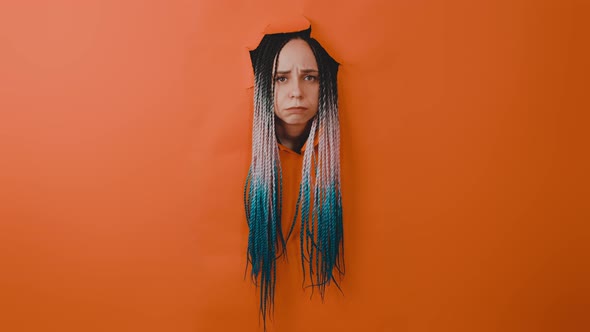 Woman's Head Sticking Out of Hole of Orange Background