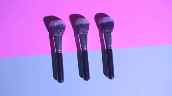 Set of Flat Top View of Professional Female Cosmetics Brush for Makeup on Pink and Blue Background