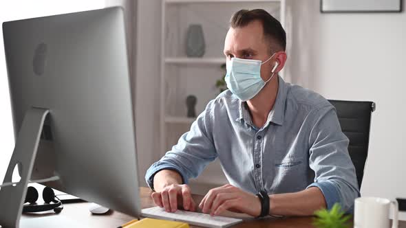 A Guy in Mask Using PC in the Office