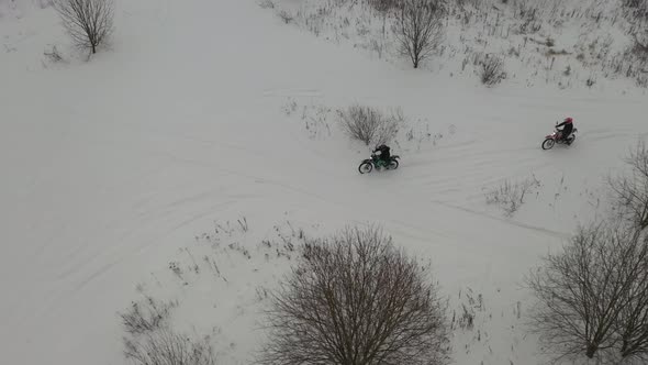 Two guys riding motorcycles in the snow