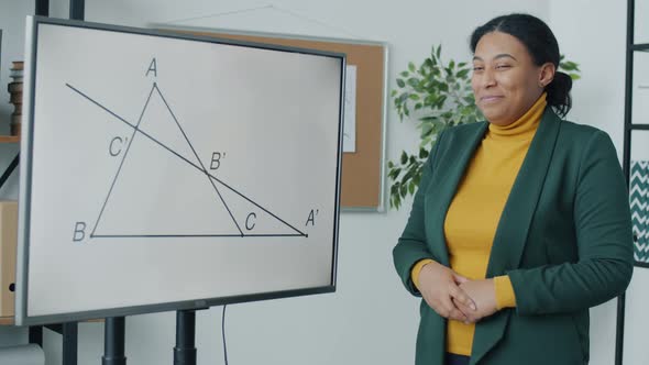 Portrait of School Teacher Speaking Pointing at Electronic Board Giving Online Lesson During Covid19 alt