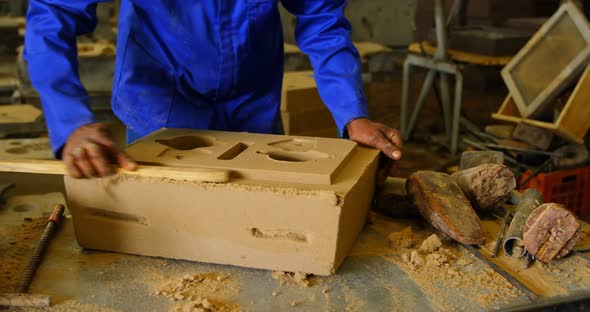 Mid section of worker making mold in foundry workshop 4k