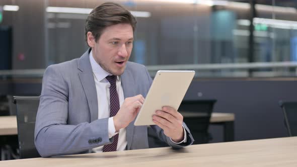 Middle Aged Businessman Celebrating Success on Tablet 