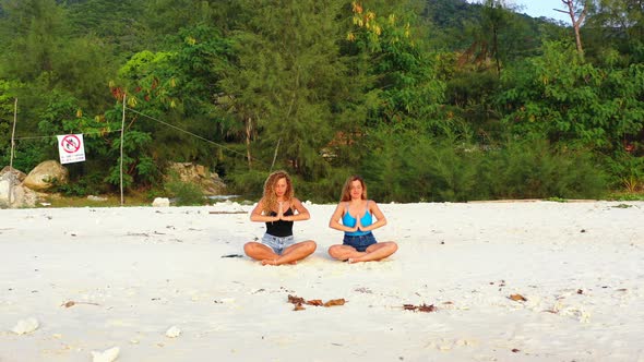 Pretty smiling ladies on vacation spending quality time at the beach on paradise white sand and blue