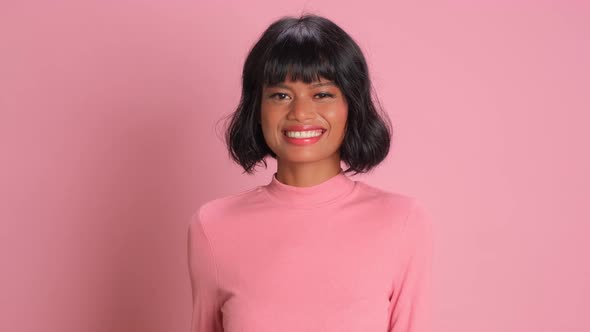 Lovely Cheerful Mixed Race Woman Dances Carefree Has Upbeat Over Pink Background