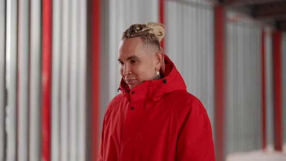 A Cute Homosexual Man with Dreadlocks in His Hair Walks Around a Modern City in Winter in a Red Warm