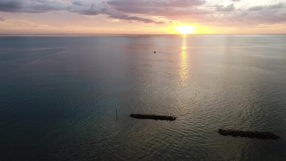 A boat returns during sunset on the Atlantic Ocean at South Beach, Marco Island, Florida.