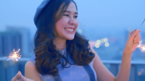 Young asian woman with sparklers is dancing and celebrating a new year.