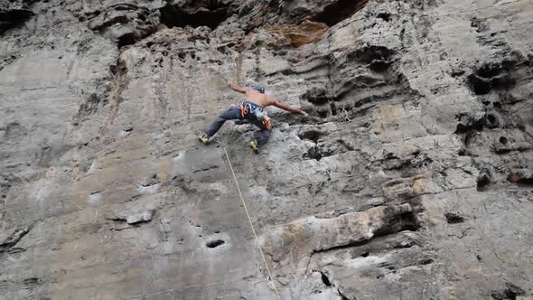 Muscular Man Climbing Up On Rocky Wall