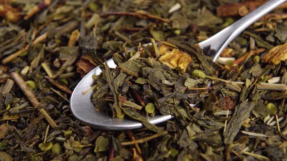 A full teaspoon of dried green hemp tea leaves in a heap. Natural legal marijuana drink. Macro