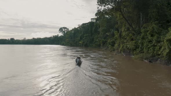 Aerial shot of small passenger boat sailing in the Amazon river. Sail on a wooden boat on the Amazon