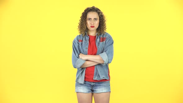 Upset Girl Shrugs and Shakes Her Head Negatively on Yellow Background at Studio