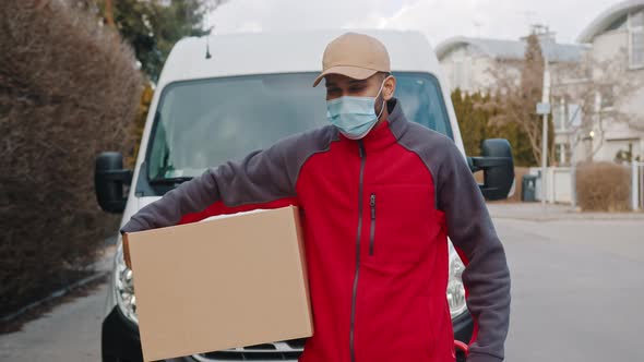 Young Indian Courier with Face Mask Delivering Parcel