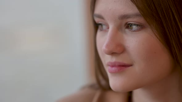 Close-up portrait of an attractive young girl smiling and looking ahead