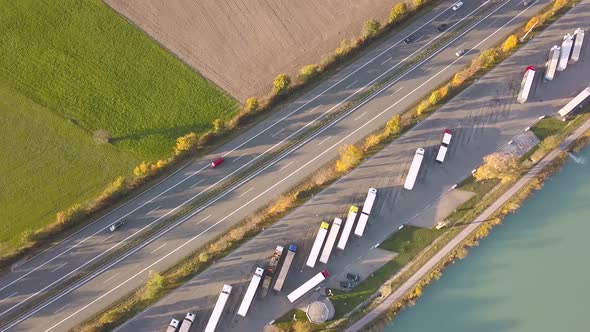 Top Down Aerial View of Highway Interstate Road with Fast Moving Traffic and Parking Lot with Parked