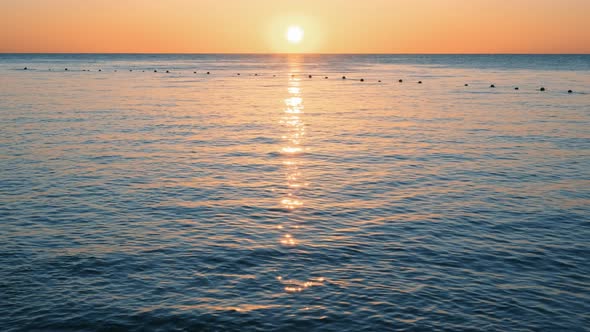 Dramatic Orange Sunrise Over the Beach. The Sun Touches Horizon. Red Sky, Yellow Sun and Amazing Sea