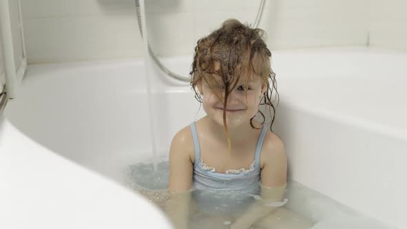 Cute Blonde Girl Takes a Bath in Swimwear