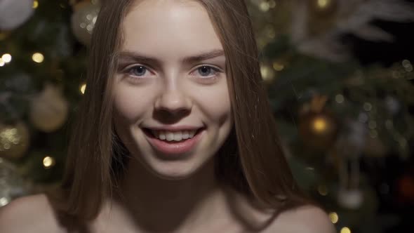 Happy Young Woman on the Background of a Dressed Up Christmas Tree