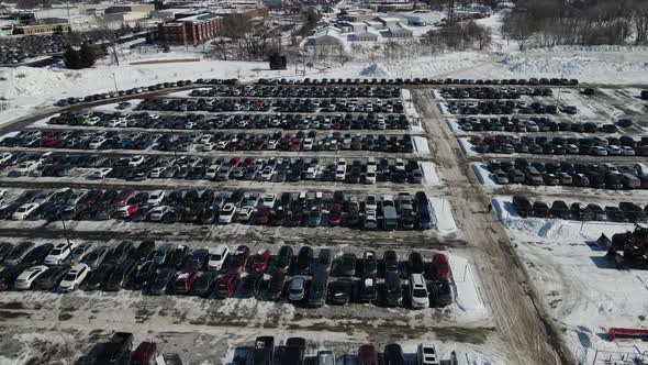 Drone view over large parking lot in winter. Symmetrical rows of vehicles.