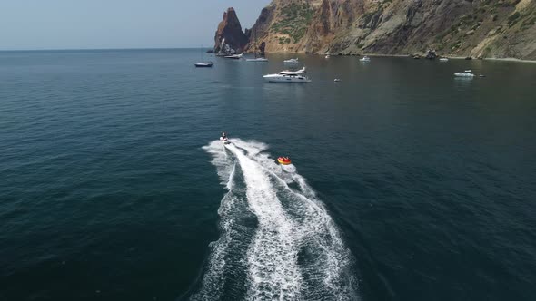 Happy People are Going to Swim on an Air Mattress Behind a Jet Ski