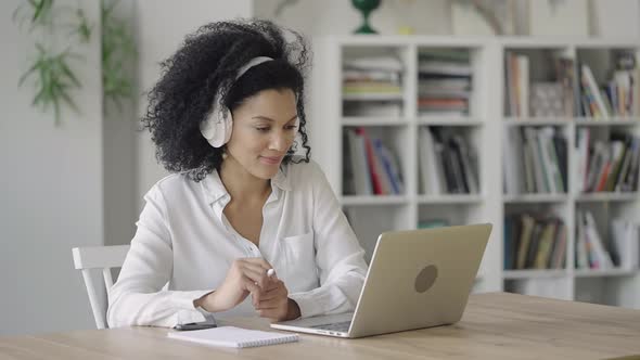 Portrait of African American Woman Talking on Video Conference Call Using Laptop and Headphones