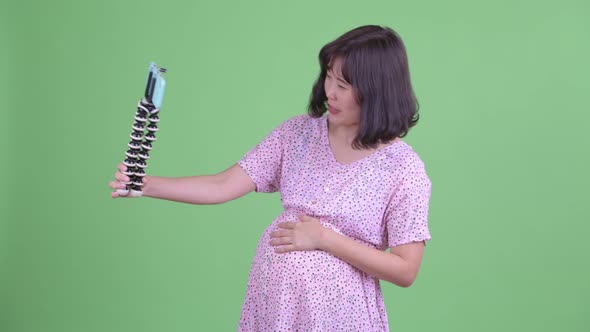 Happy Asian Pregnant Woman Vlogging with Phone