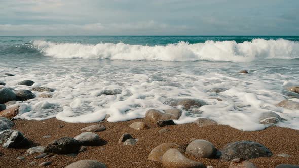 Sea Waves Are Crashing on Stones and Spraying in Slow Motion. Beautiful Beach in Crimea with Stones