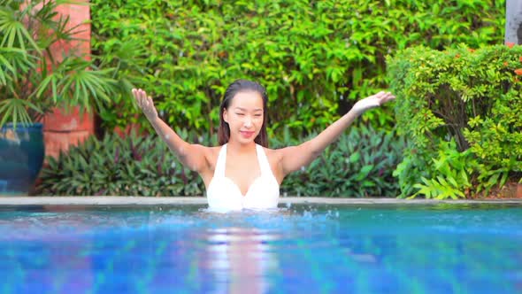 Young asian woman enjoy around outdoor swimming pool for leisure