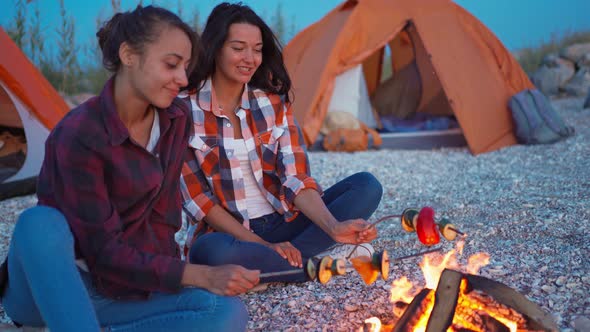 Lovely Female Couple Roasting Vegetables on Fire Sitting on Beach at Tents