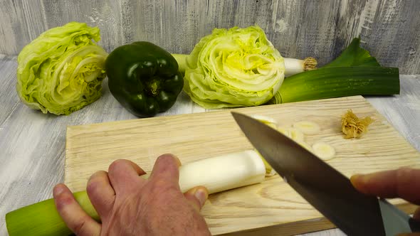 Cutting leeks into thin slices, cooking vegetables