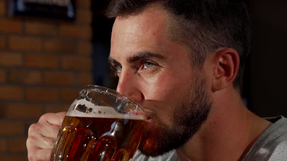 Handsome Bearded Man Smiling Joyfully While Drinking Beer