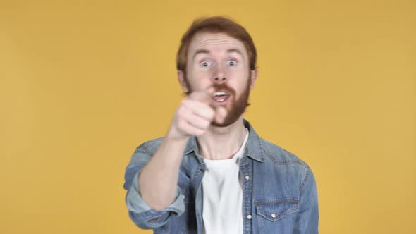 Redhead Man Pointing at Camera Yellow Background