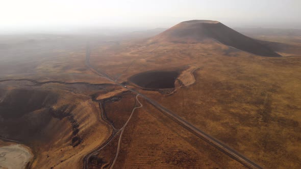 Mars Rover Moving on a Road Near Volcanic Cone and Crater on Red Planet