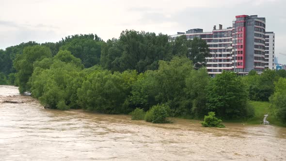 Wide dirty river with muddy water in flooding period during heavy rains in spring.