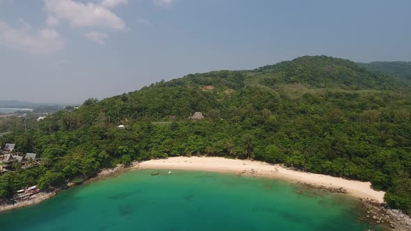 Aerial wide shot of a beautiful beach with turqoise water in southern Thailand