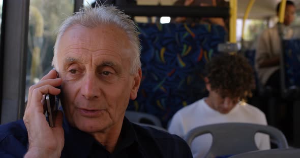 Senior man talking on mobile phone while travelling in bus 4k