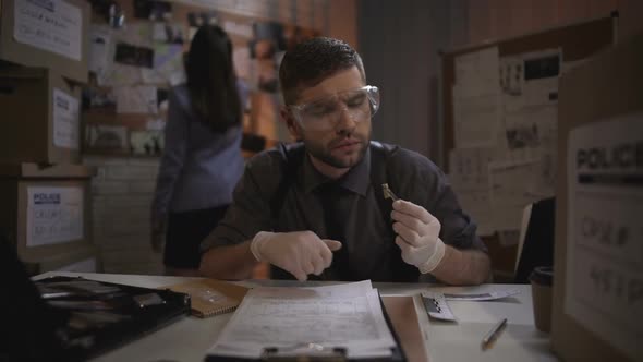 Ballistics Officer Comparing Bullet Size, Examining Evidence From Murder Scene