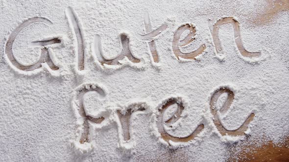 The word gluten free written on sprinkled flour 4k